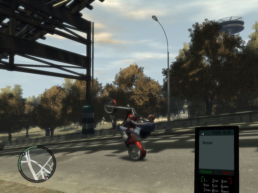 Grand Theft Auto IV (Windows) screenshot: Roman calling me while I'm doing a wheelie.