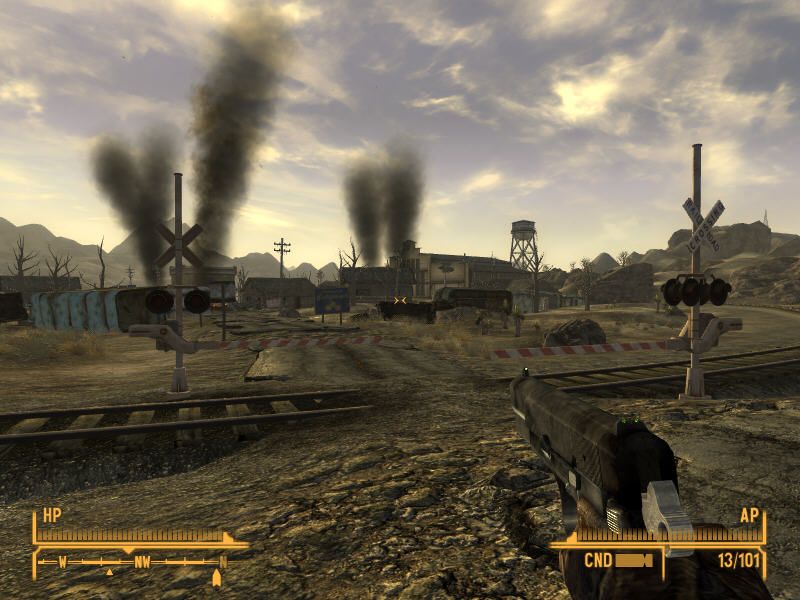 Fallout: New Vegas (Windows) screenshot: Typical Fallout scene: broken railway that doesn't lead anywhere, smoke over ruined houses... desolation and sadness