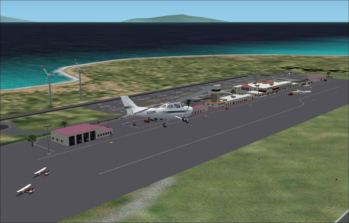 Scenery Spain 3: Canary Islands (Windows) screenshot: Las Palmas airport fly-by showing the buildings and static aircraft Flight Simulator 2002
