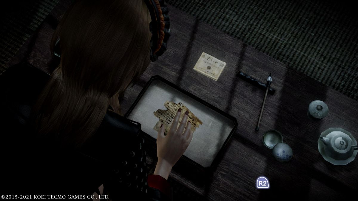 Fatal Frame: Maiden of Black Water (PlayStation 5) screenshot: Watch out for ghost hands trying to grab you when reading for an object