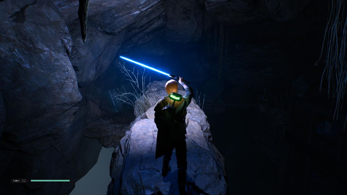 Star Wars: Jedi - Fallen Order (PlayStation 5) screenshot: Using lightsaber to light a path through the dark cavern