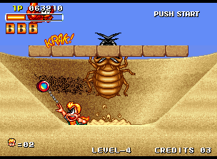 Spinmaster (Neo Geo) screenshot: Fighting a giant beetle in the quicksand