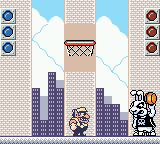 Wario Land II (Game Boy Color) screenshot: Boss fight - You got to beat this bunny by making three shots in the basket...