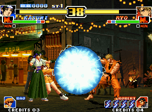 The King of Fighters '99: Millennium Battle (Neo Geo) screenshot: Fearing a possible attack of Ryo, Kasumi calls Bao to help executing his DM Psycho Ball Attack: Max.