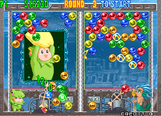 Bust-A-Move 4 (Arcade) screenshot: Player vs Computer mode - Kurol (the kid in the frog costume) against Marino