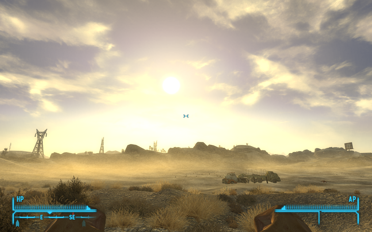 Fallout: New Vegas (Windows) screenshot: Just admire the gorgeous sunrise. The vast desert lies ahead of me... Some construction, old trucks, towers... I have no idea why I'm making fists
