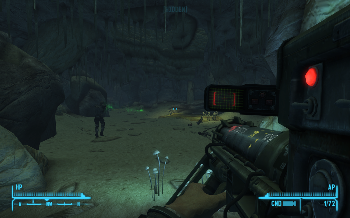Fallout: New Vegas (Windows) screenshot: While I'm trying to figure out how to use this huge new weapon, my trusty sidekick fires at the walls of this cave with his energy rifle