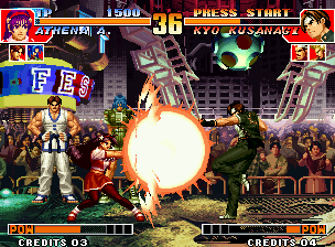 The King of Fighters '97 (Neo Geo) screenshot: Kyo Kusanagi performs a kick at the same time that Athena Asamiya executes her Nu Psycho Reflector.