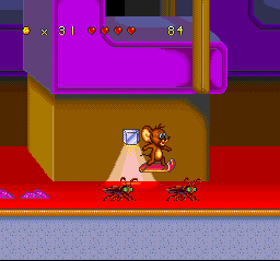 Tom and Jerry (SNES) screenshot: Jerry in the movie theater: now, he's using a ticket-stub-cum-surfboard to attack some cockroaches.