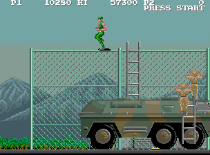 M.I.A.: Missing in Action (Arcade) screenshot: Second stage features right-to-left scrolling in this version. Running on a fence