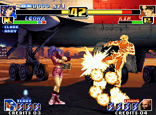 The King of Fighters '99: Millennium Battle (Neo Geo) screenshot: After having implanted her Earring Bomb in Kim, Leona stands back and triggers the artifact in him.