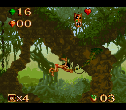 Disney's The Jungle Book (SNES) screenshot: Swinging on a vine. The mask above, if you can get it, gives you invulnerability, for a short time.