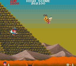 Insector X (Arcade) screenshot: Flying past a pyramid.
