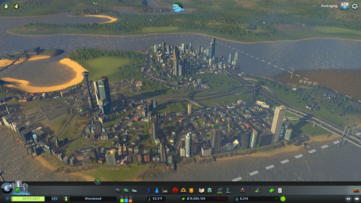 Cities: Skylines (Windows) screenshot: A modest town has developed into a fairly mature map square. The city's sewage runoff flowing on the right...