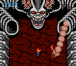 Super Contra (NES) screenshot: This guy isn't that tough. The snake goes into the other hole after crawling around for a while