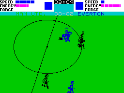 Super Soccer (ZX Spectrum) screenshot: A successful tackle has got me the ball. The two active players have 'halos' above them. Also note that any opposing blue player near a black player will colour the black player blue too.