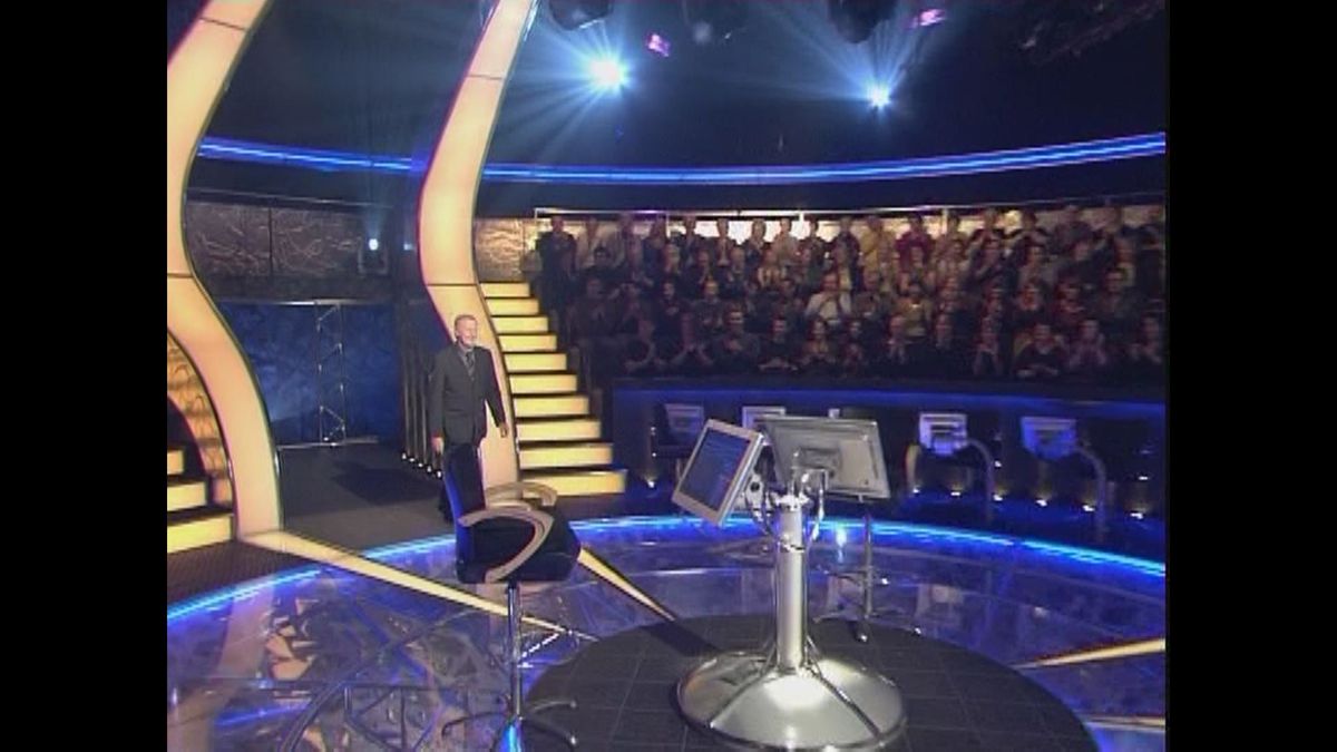 Who Wants To Be A Millionaire: Family Entertainment Edition (DVD Player) screenshot: Chris Tarrant appears, addresses the live and home audience, and then takes his place in the centre of the stage